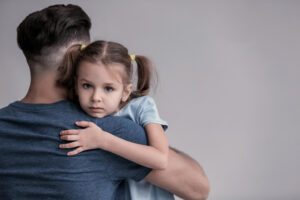 sad little girl hugging her father