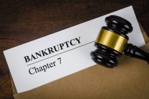 Bankcrupty Chapter 7 text on Document form and Wooden Gavel on office desk.