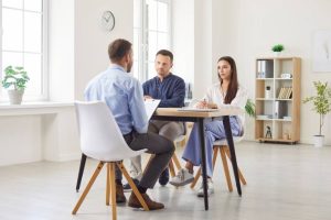 Angry clients submit customer complaint to bank worker. Discontent disappointed couple sit at table, argue deal contract terms